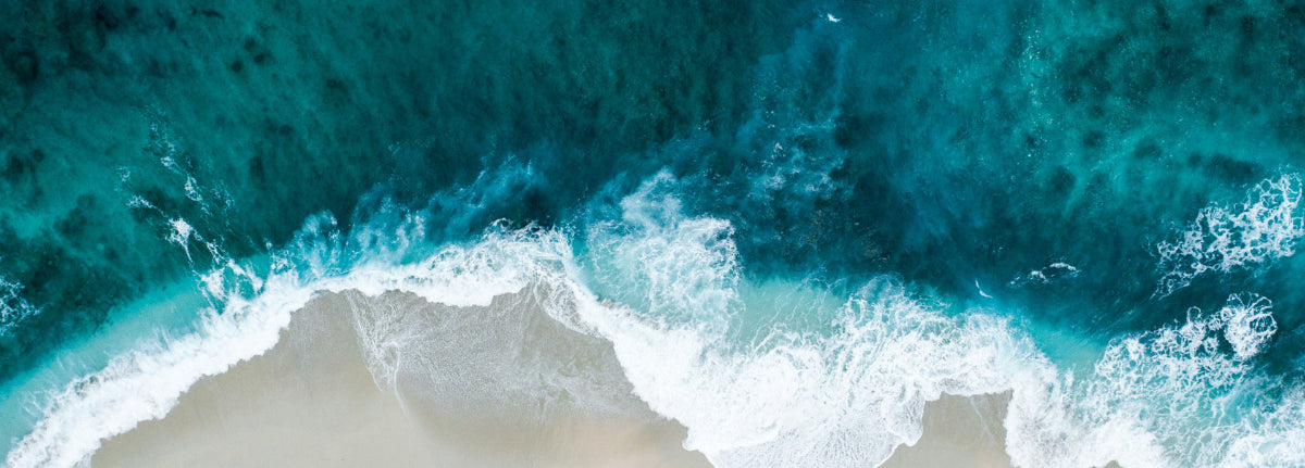 Aerial view of ocean waves crashing onto a beach